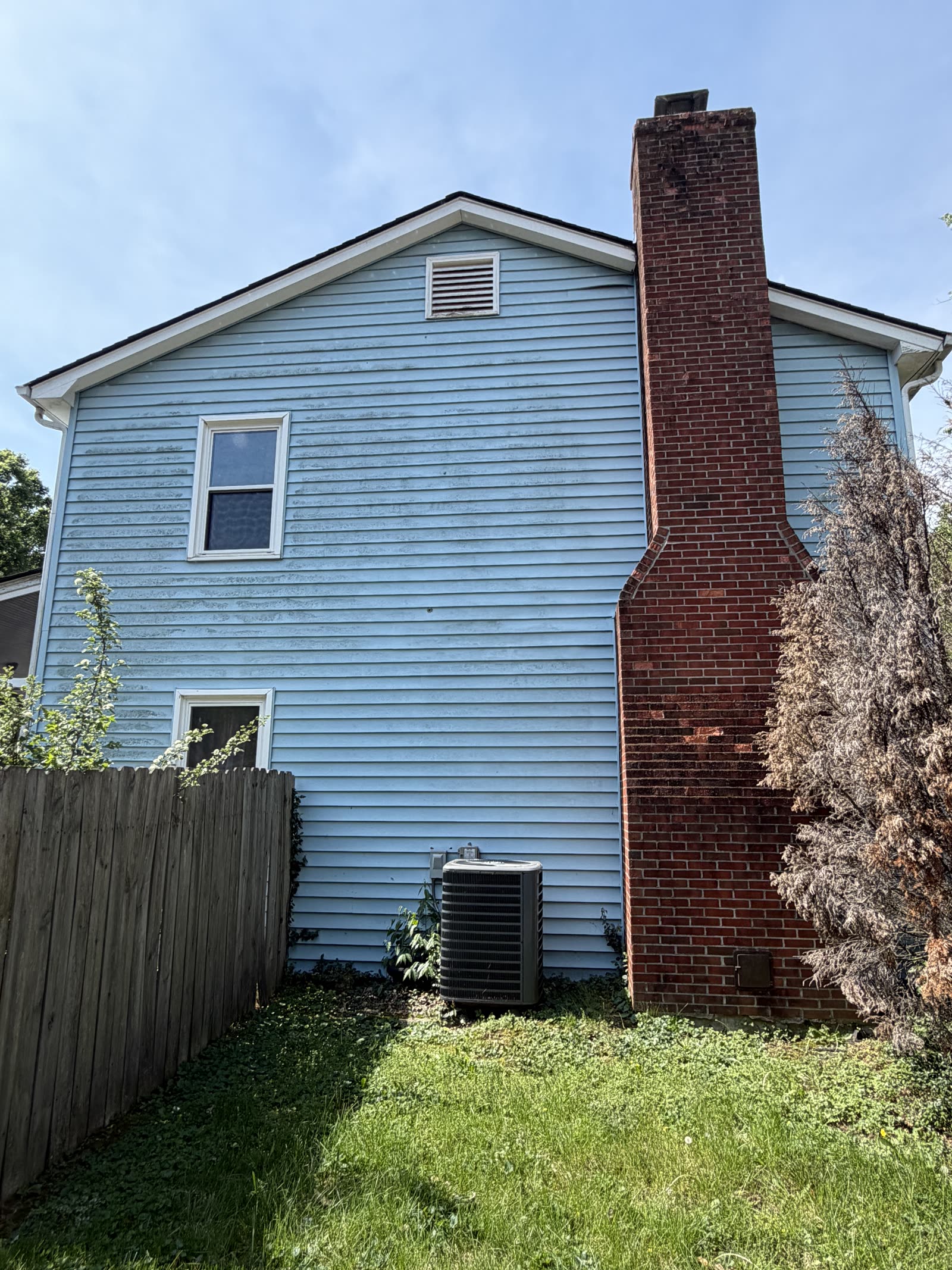 Oxidized blue siding with chalky buildup before pressure washing
