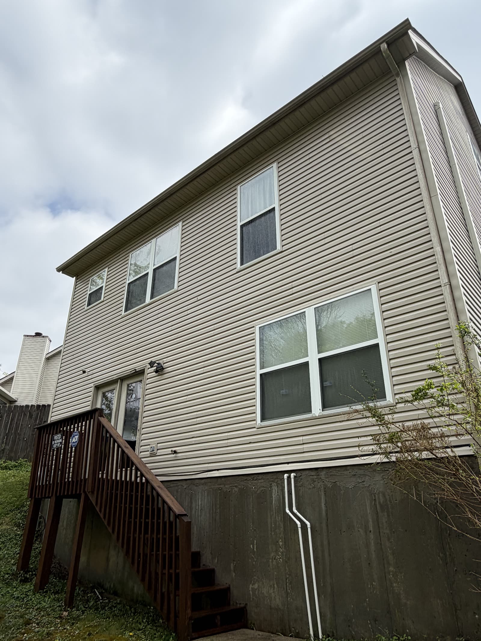 Two-story tan siding cleaned by Mean and Clean Pressure Washing in Central Kentucky